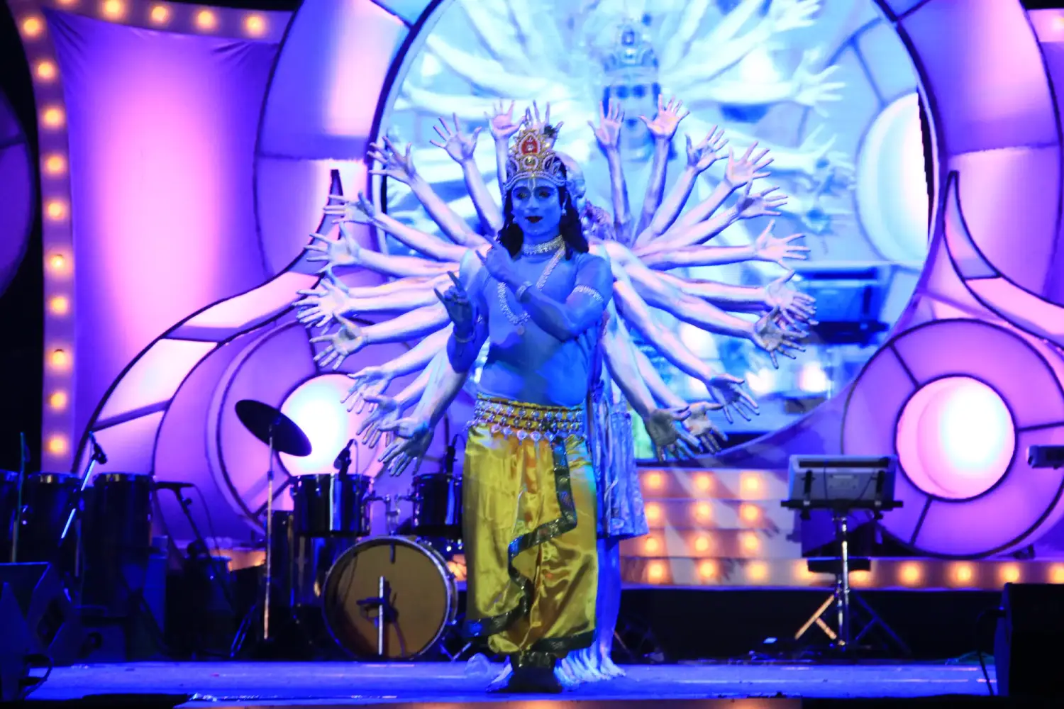 Man and woman speaking on stage at night with blue lighting